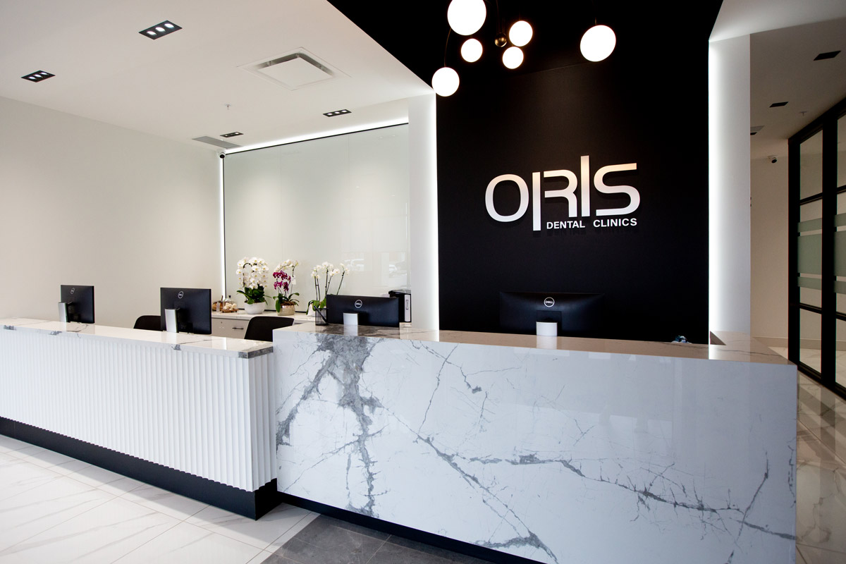 Reception desk at ORIS Dental Clinics, featuring a sleek design and a welcoming atmosphere for Oral and Maxillofacial Surgery in Richmond Hill